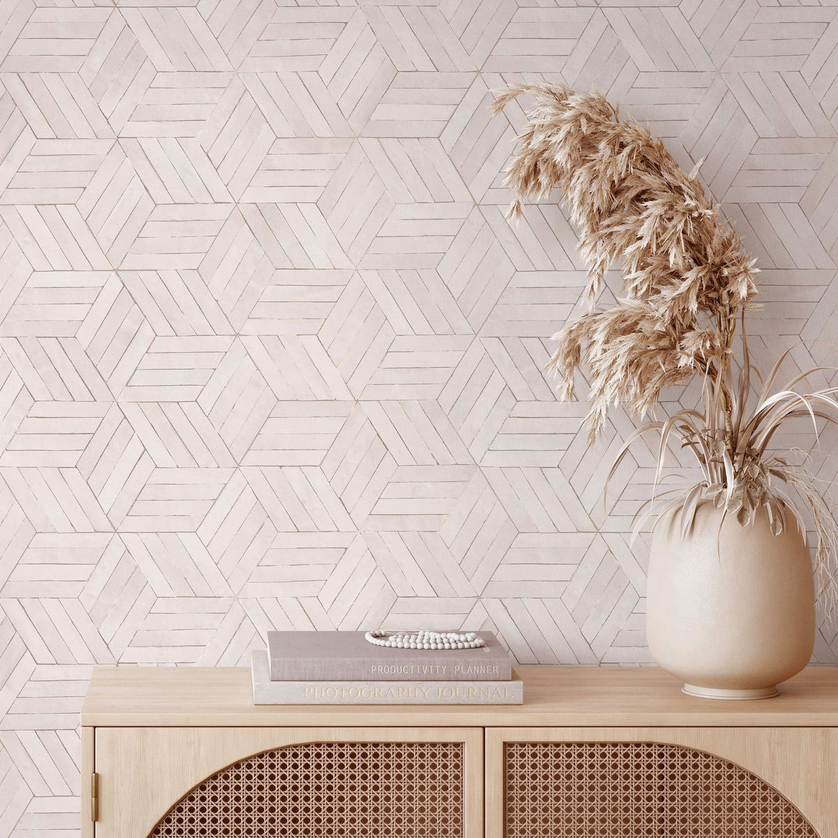 Marburg Leyla 81699 Geometric line-pattern wallpaper in light neutral tones behind a wooden console with a rounded vase of dried grasses and a small stack of books.