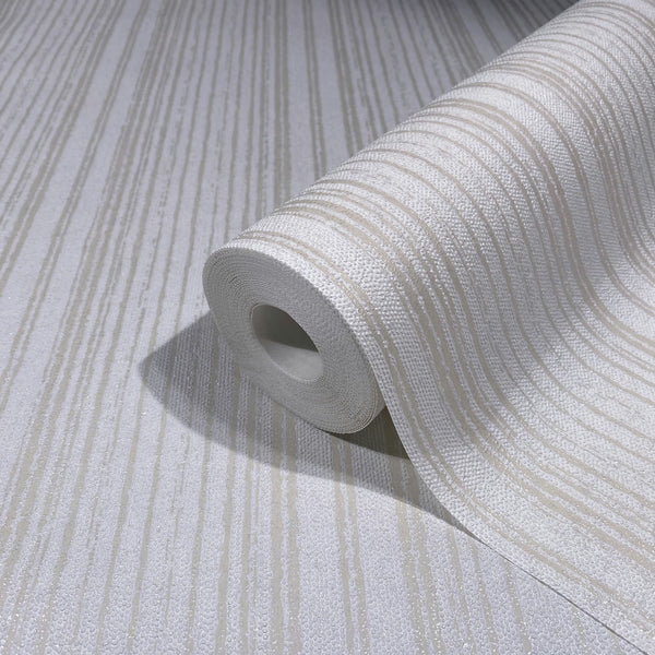 Marburg Leyla 82443 Close-up of a wallpaper roll with beige and white irregular vertical stripes and a textured surface, resting on a matching unrolled sheet.