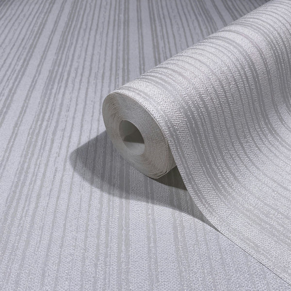 Marburg Leyla 82445 Close-up of a white wallpaper roll with vertical textured stripes, resting on the matching unrolled wallpaper.