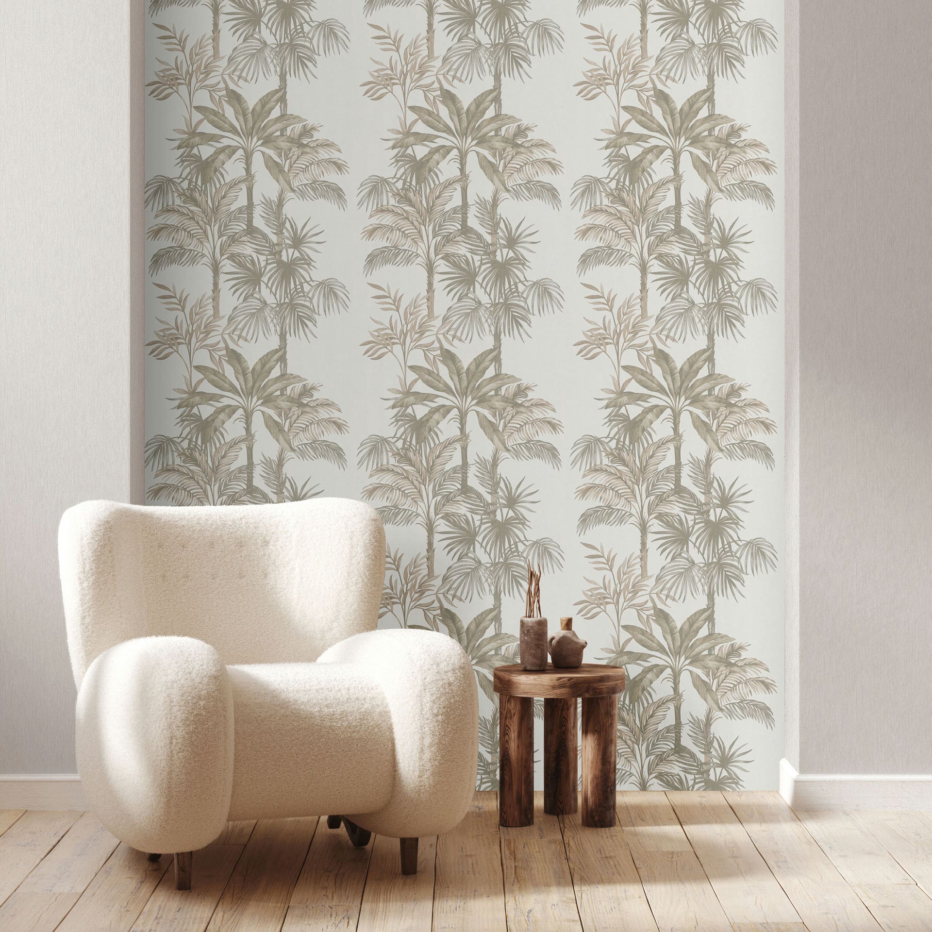 Marburg Leyla 82454 Feature wall with beige palm tree patterned wallpaper on a light background, shown behind a cream armchair and a small round wooden side table with decorative objects on wood flooring.