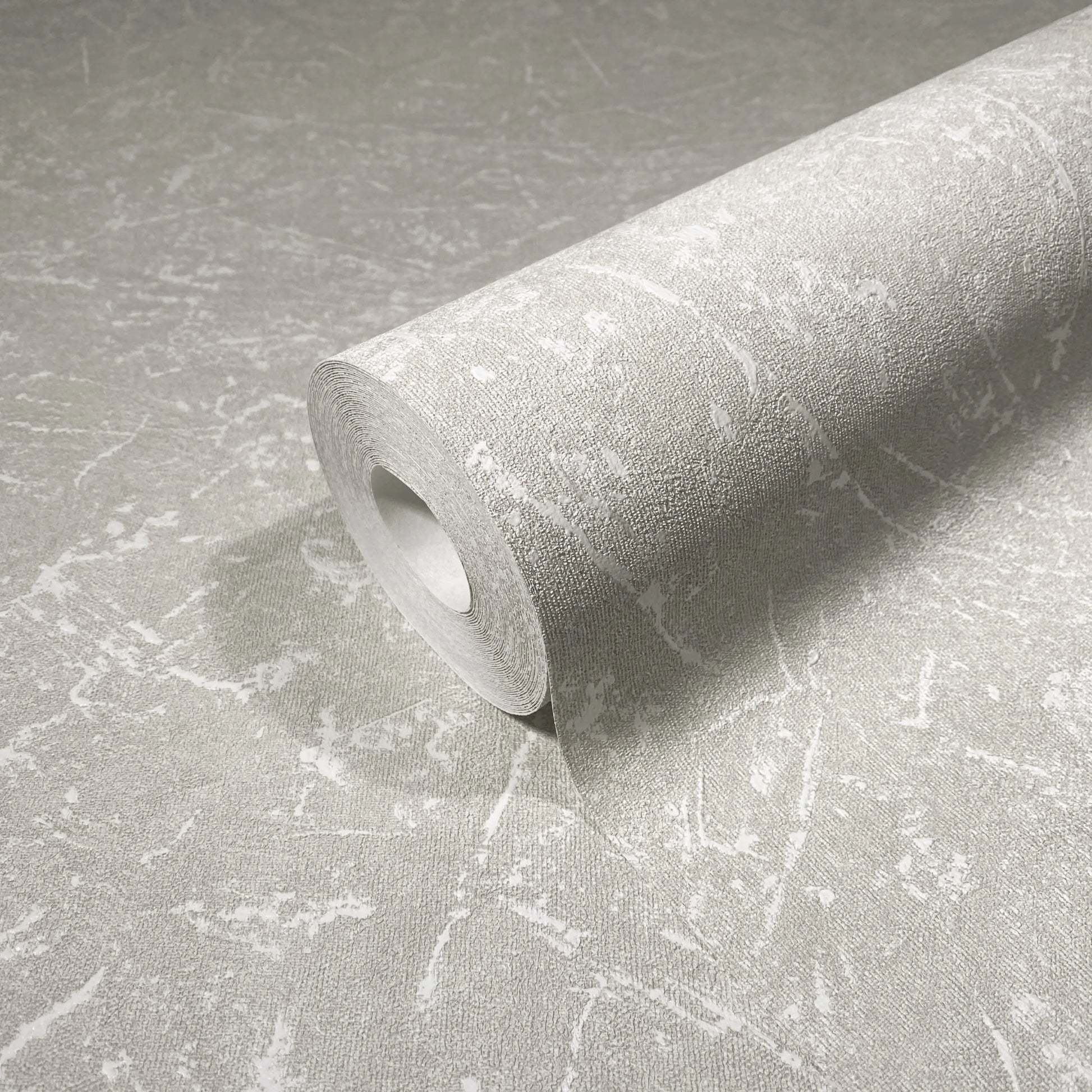Marburg Loft Superior 34152 A wallpaper roll resting on matching unrolled paper, showing a light gray abstract marbled pattern with fine texture.