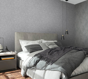 Marburg Loft Superior 34155 Bedroom scene featuring gray textured wallpaper with fine linear markings behind an upholstered bed, two black pendant lights, a nightstand, and an adjacent wall in a darker gray geometric pattern.