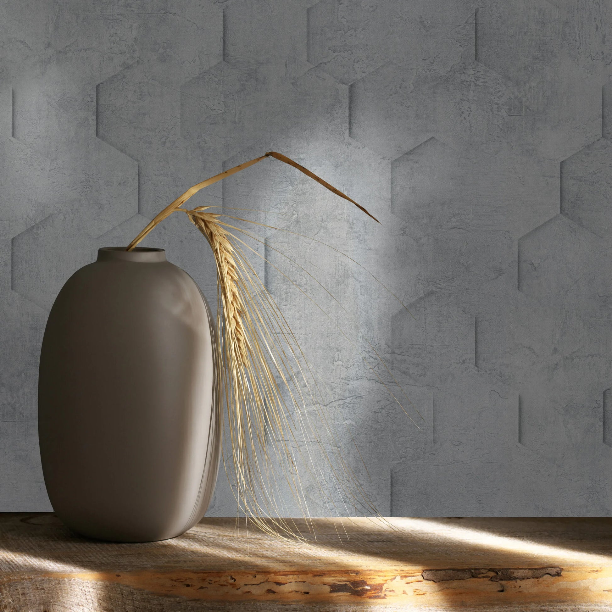 Marburg Loft Superior 34160 Close-up of gray geometric textured wallpaper behind a matte vase holding dried wheat on a rustic wood shelf with light and shadow.