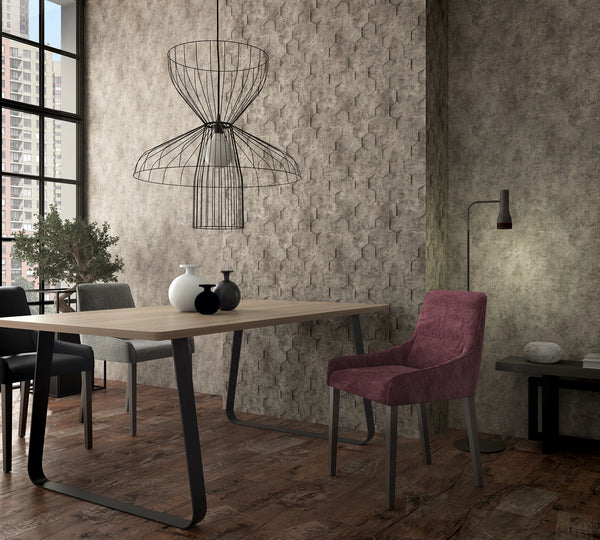 Marburg Loft Superior 34162 Dining room scene featuring a brown hexagon‑textured wallpaper as a feature wall behind a wood table with vases, upholstered chairs, a wireframe pendant light, and a floor lamp beside a large window with city view.