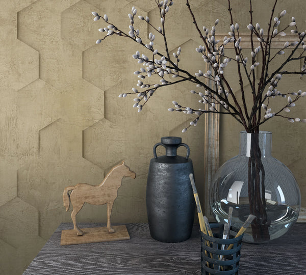 Marburg Loft Superior 34163 Brown wallpaper with a raised hexagonal pattern behind a tabletop vignette featuring a clear glass vase with branches, a dark vessel, a small wooden horse figure, a brush holder with paintbrushes, and a leaning frame.