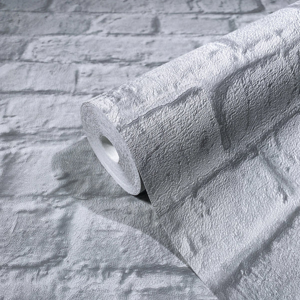 Marburg Loft Superior 34167 Close-up of a wallpaper roll with a gray textured brick pattern resting on a matching unrolled sheet.