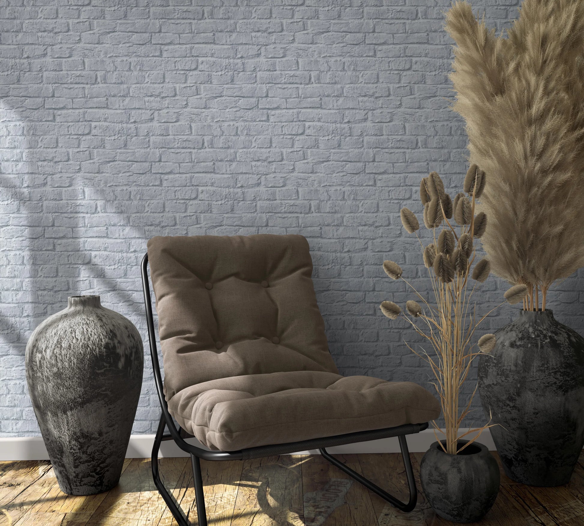 Marburg Loft Superior 34167 Gray brick wallpaper behind a cushioned lounge chair, ceramic vases, and dried pampas grass on a wooden floor.