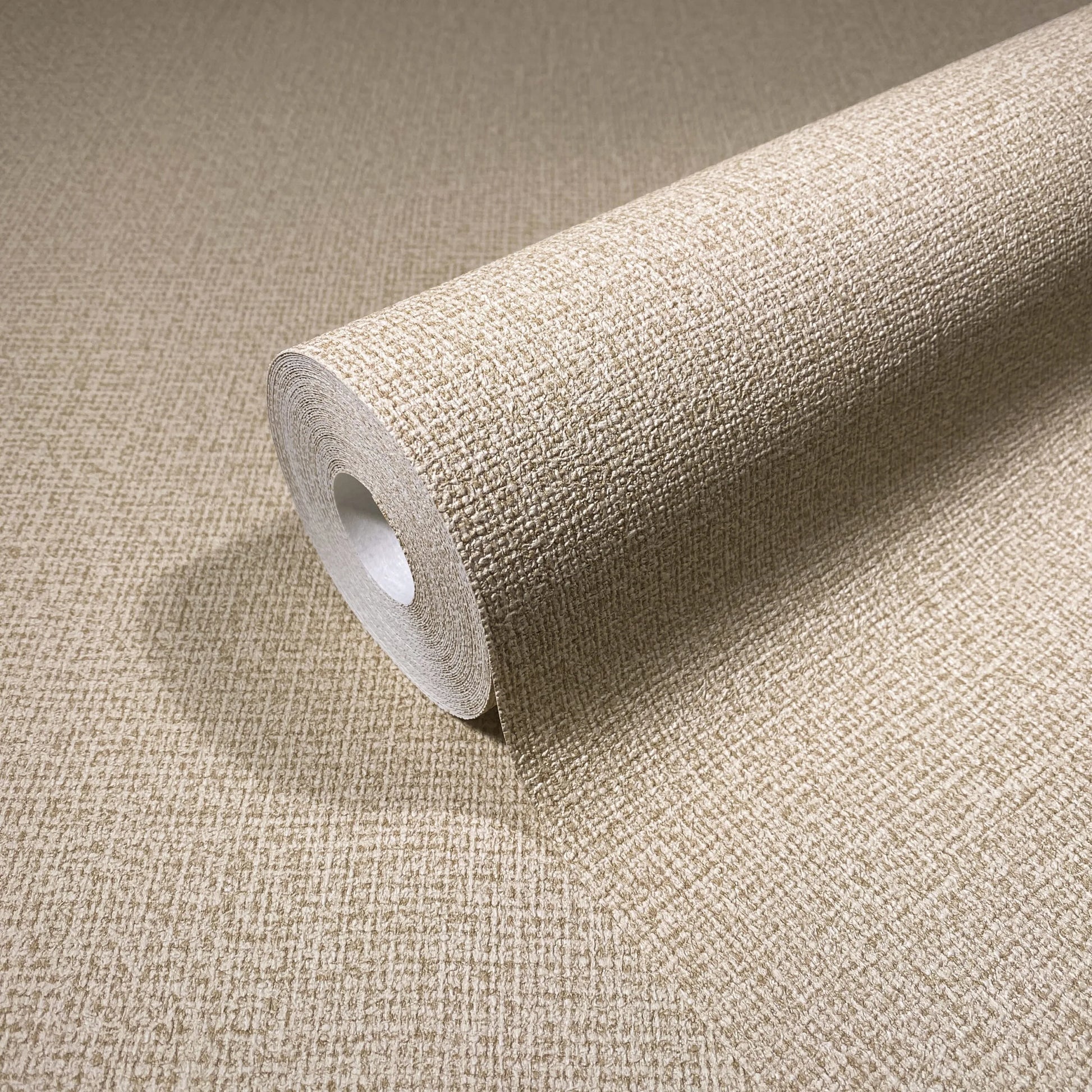 Marburg Loft Superior 34175 Close-up of a beige textured crosshatch wallpaper roll resting on a matching unrolled sheet.