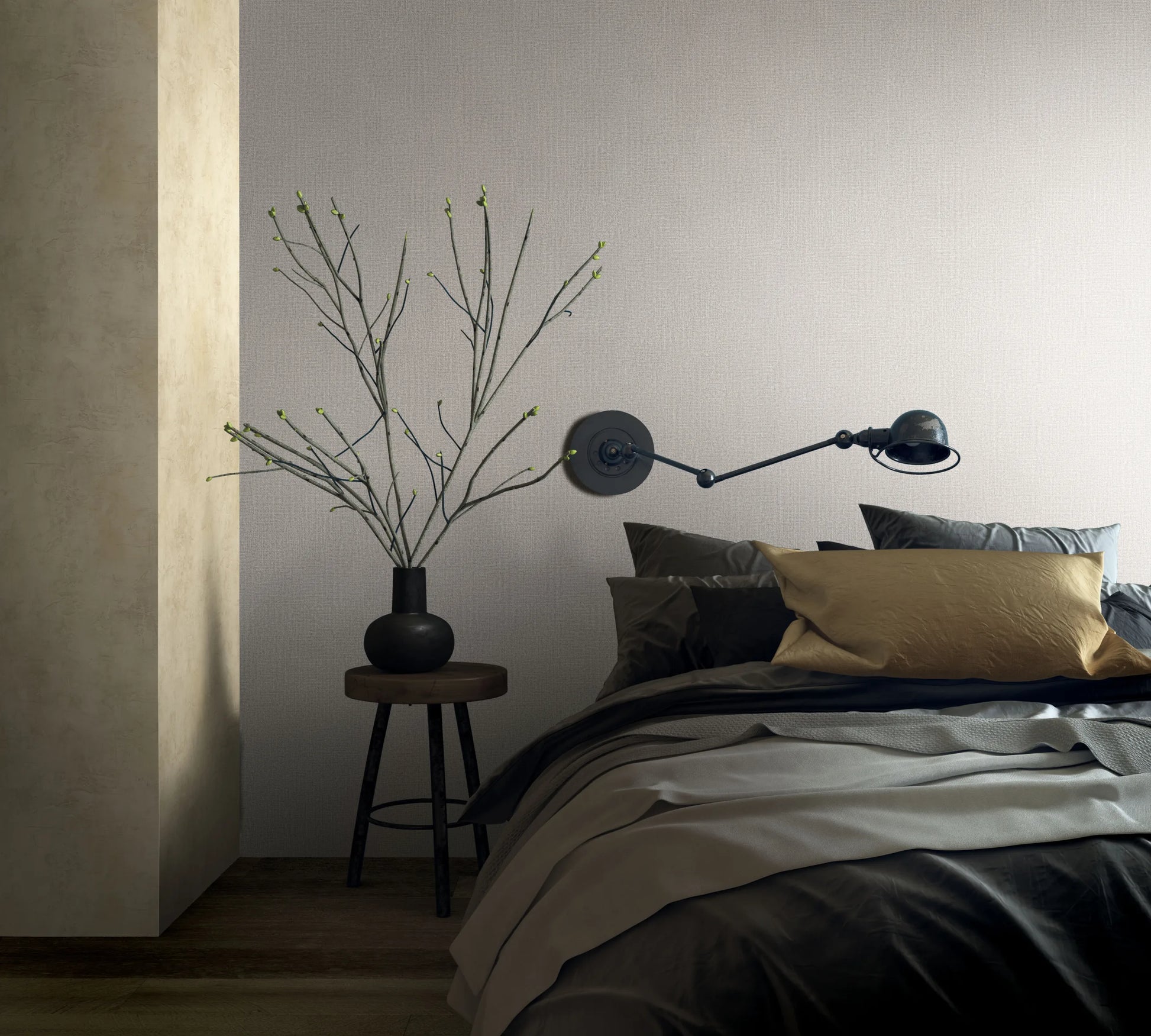 Marburg Loft Superior 34176 Bedroom scene showing a light neutral textured wallpaper with a fine woven look behind a bed, a black swing-arm wall lamp, and a small stool holding a matte black vase with branches.