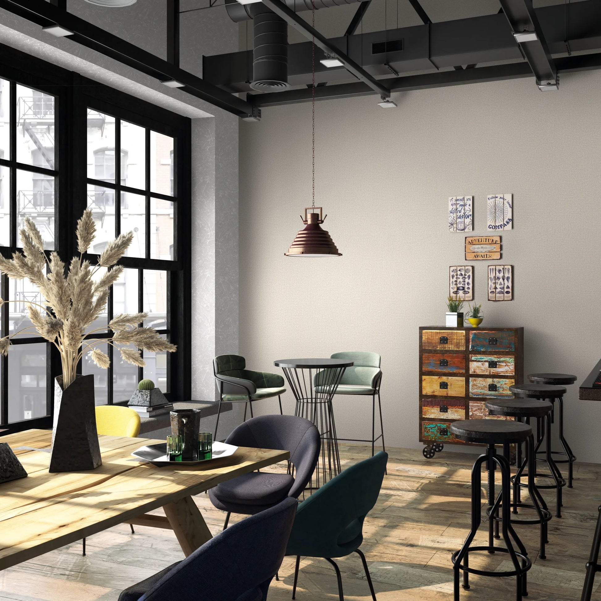 Marburg Loft Superior 34177 Industrial-style cafe interior showing a beige textured wallpaper feature wall, a hanging pendant light, bar stools at a counter, mixed chairs and tables, a colorful drawer cabinet with small wall art, and large black-framed windows.