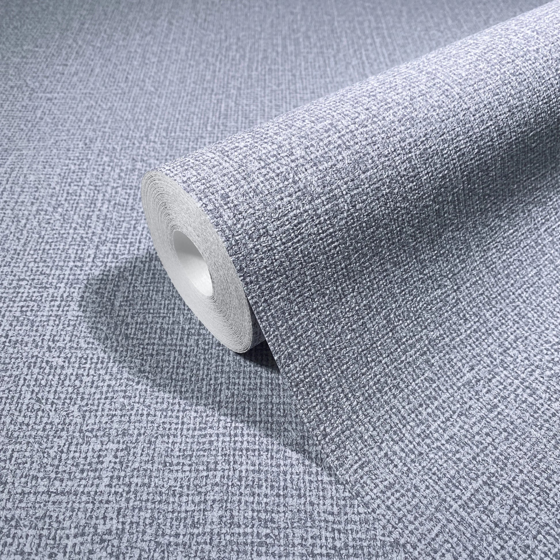 Marburg Loft Superior 34182 Wallpaper roll partially unrolled on a matching surface, showing a small-scale woven crosshatch texture in light grey.