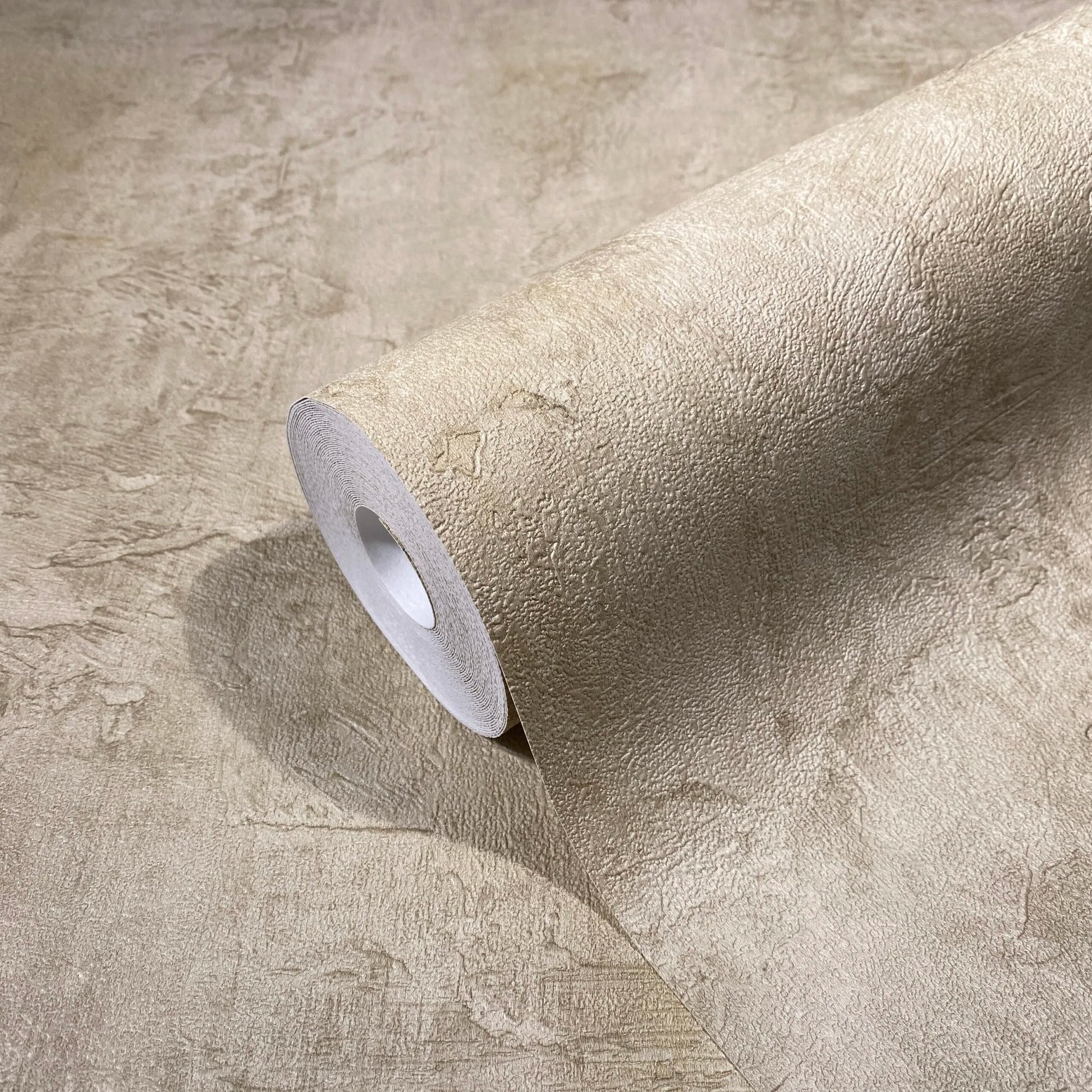 Marburg Loft Superior 34190 Close-up of a wallpaper roll with a textured plaster effect in a neutral light brown, resting on a matching unrolled sheet.