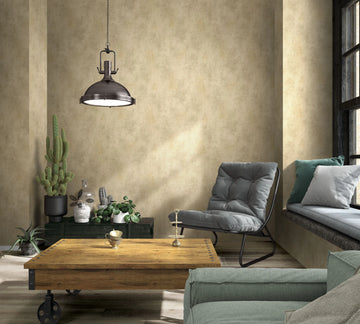 Marburg Loft Superior 34190 Living room with warm beige mottled wallpaper. An industrial pendant hangs above a wood coffee table on casters, with a gray lounge chair, window bench with cushions, a sofa corner, and several potted plants including cacti near a window.