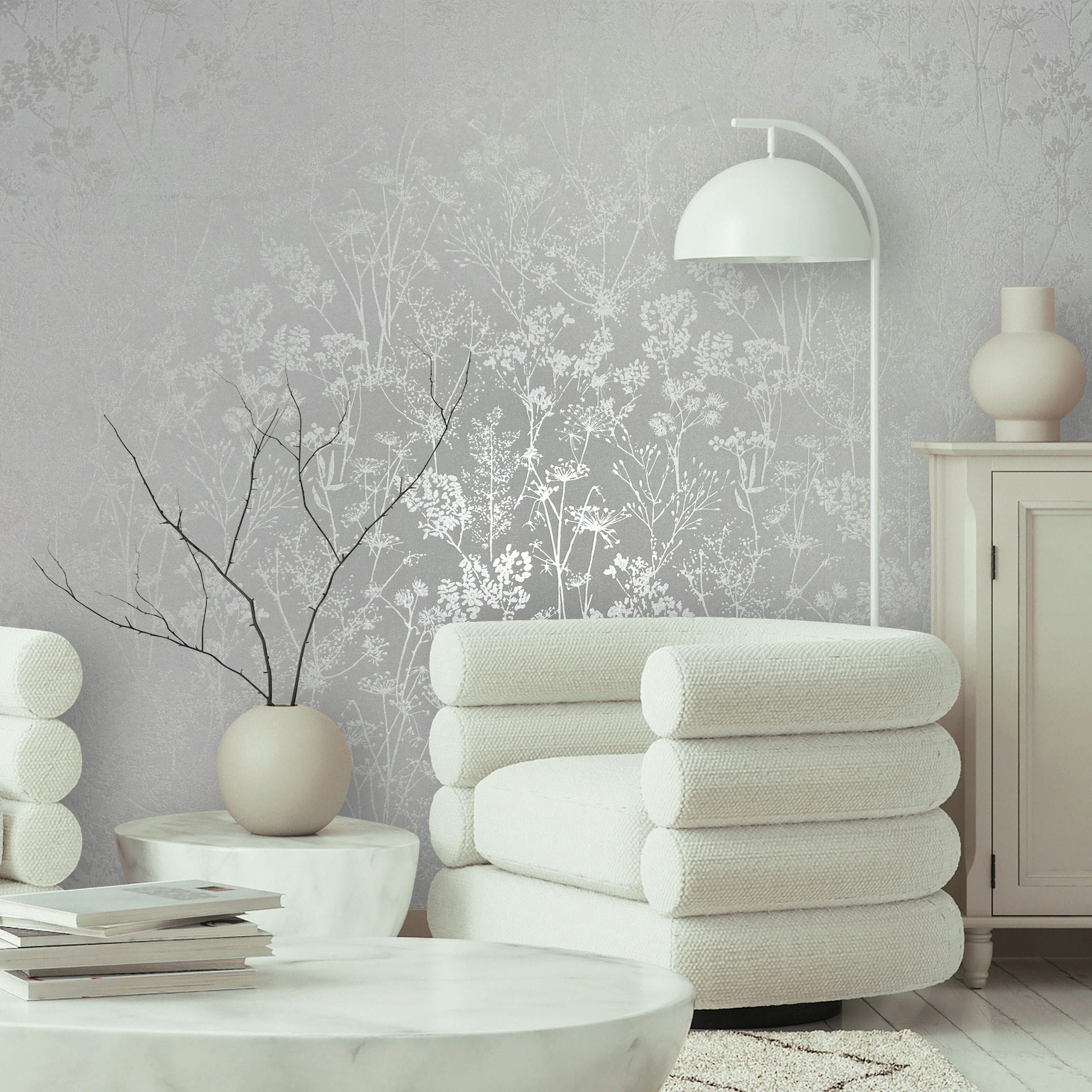 Marburg Mona 82462 Light gray wallpaper with delicate white botanical silhouettes of wildflowers and stems wallpaper on a living room feature wall.