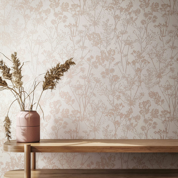 Marburg Mona 82463 Beige floral silhouette wallpaper on a white wall behind a light wood console with a pink vase holding dried grasses.