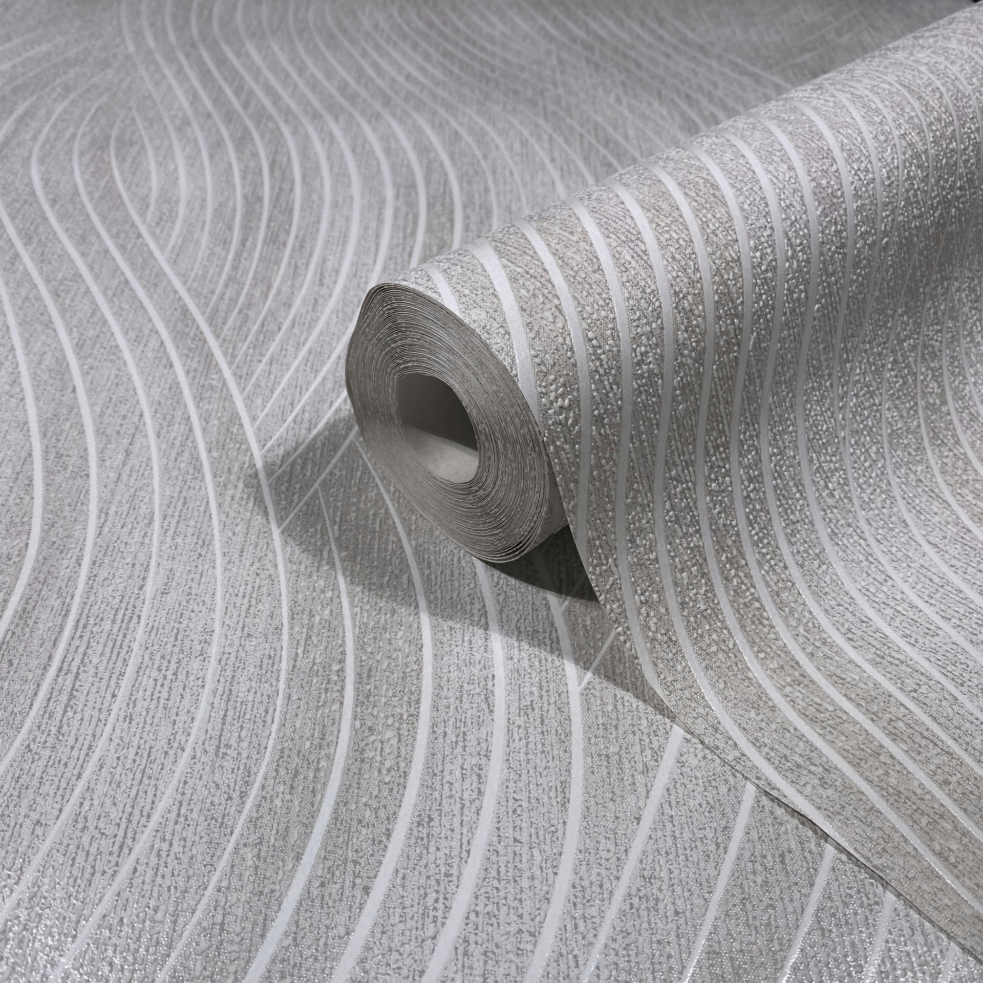 Marburg Mona 82474 Wallpaper roll resting on a matching unrolled sheet, showing a gray and white wavy stripe pattern with textured detail.