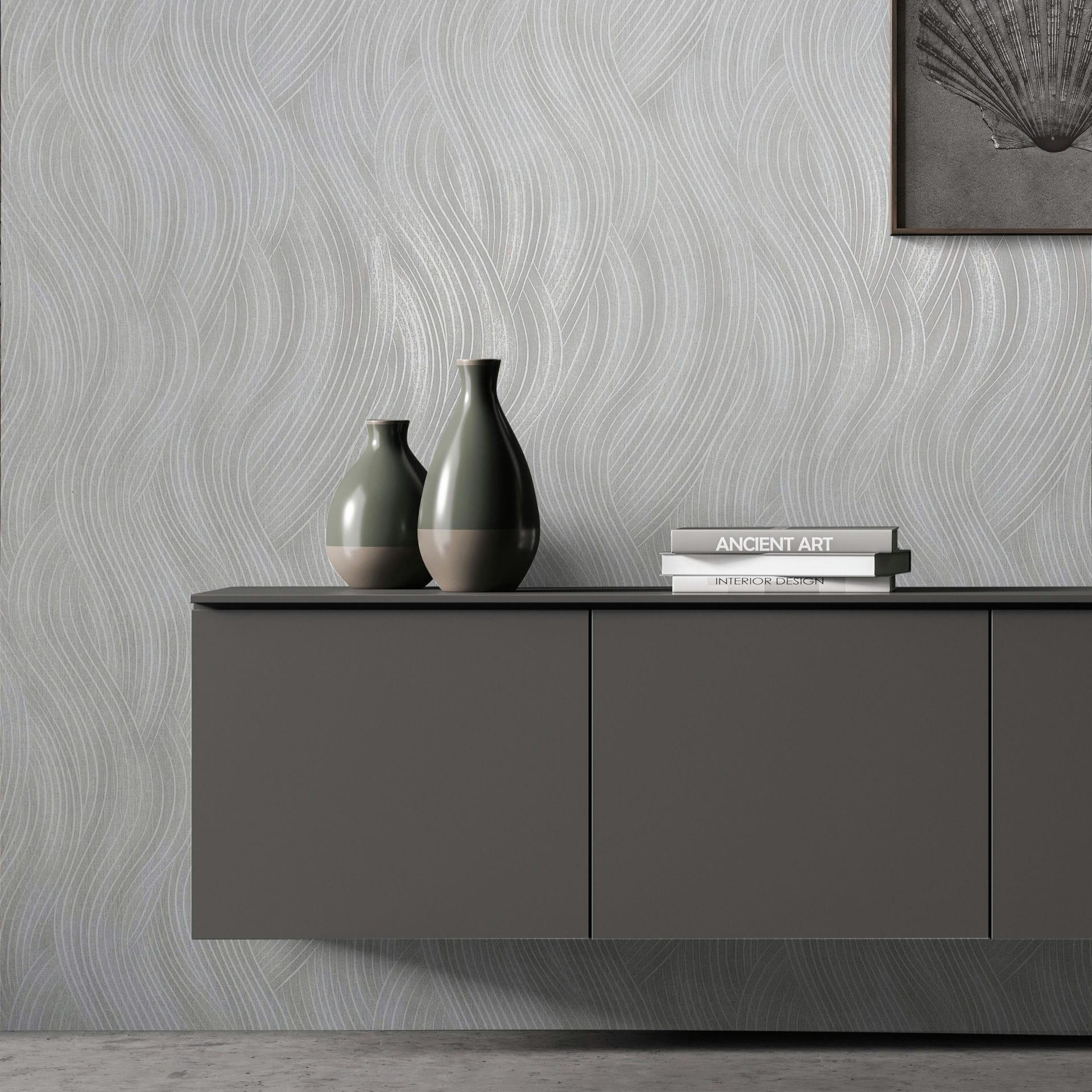 Marburg Mona 82474 Gray wallpaper with a flowing wavy line pattern shown behind a floating cabinet, two ceramic vases, stacked books, and a partial framed artwork.