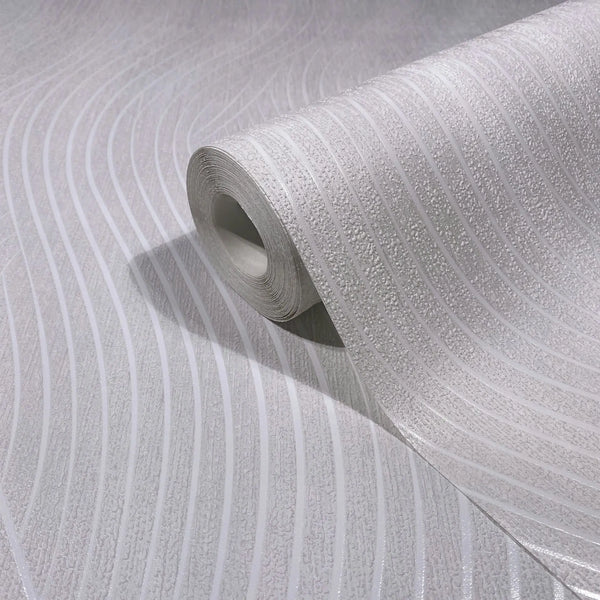 Marburg Mona 82476 Close-up of a white wallpaper roll with curved wavy stripes and textured bands, shown partially unrolled on a matching surface.
