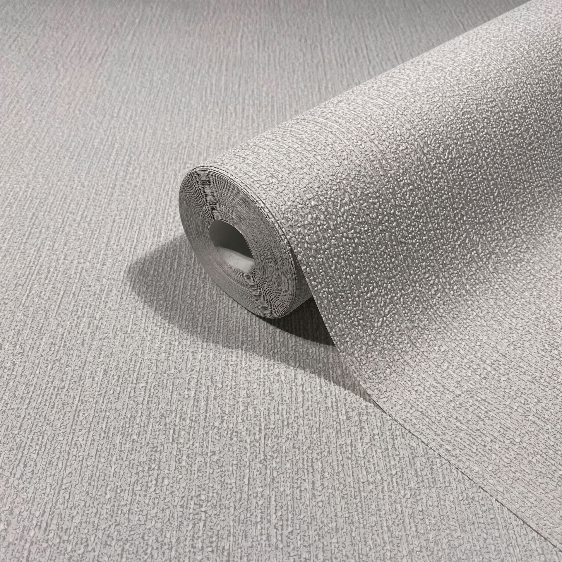 Marburg Mona 82479 Close-up of a light gray textured wallpaper roll resting on the same pattern surface, showing raised stippled texture and subtle vertical lines.