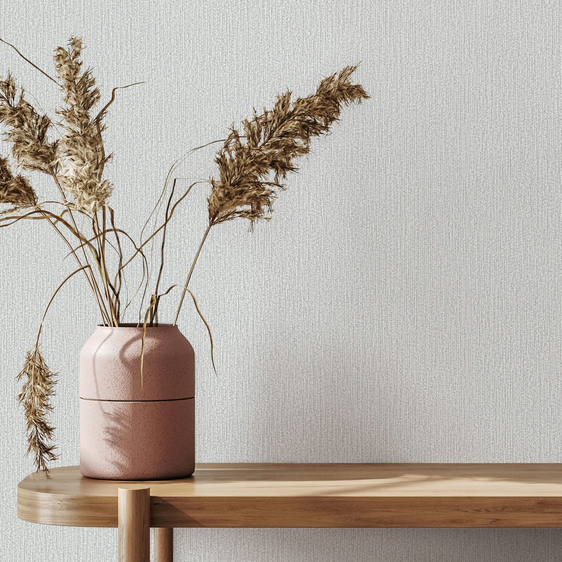 Marburg Mona 82479 Light gray textured wallpaper with fine vertical lines behind a wooden console topped with a pink vase holding dried grasses.