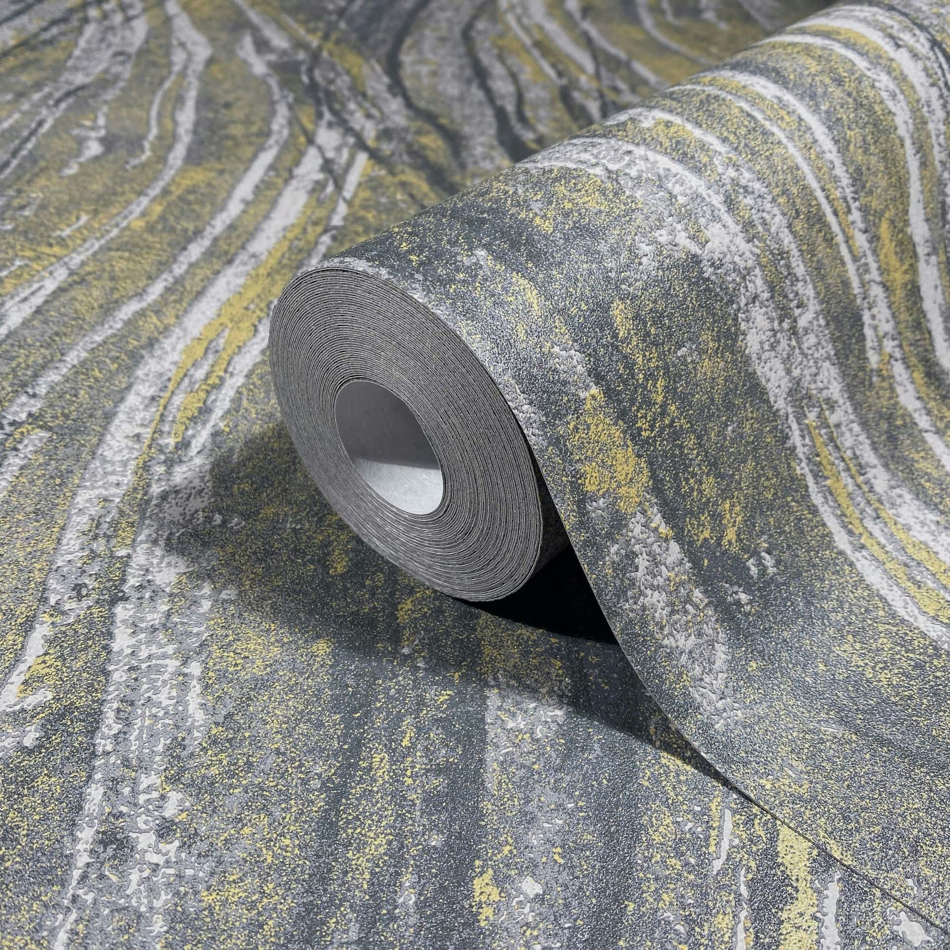 Marburg Naomi 82496 Angled close-up of a gray and yellow streaked wallpaper roll resting on the matching unrolled paper.