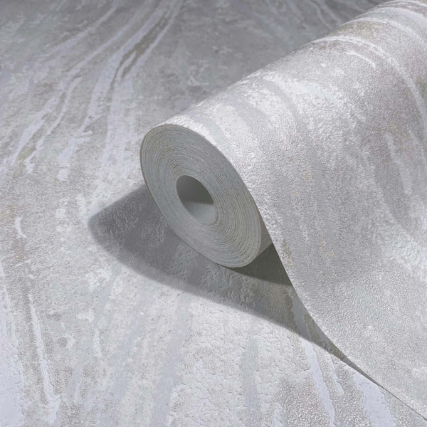 Marburg Naomi 82497 A gray and white abstract marbled wallpaper shown as a roll partly unrolled on matching wallpaper, highlighting the subtle textured streak pattern.