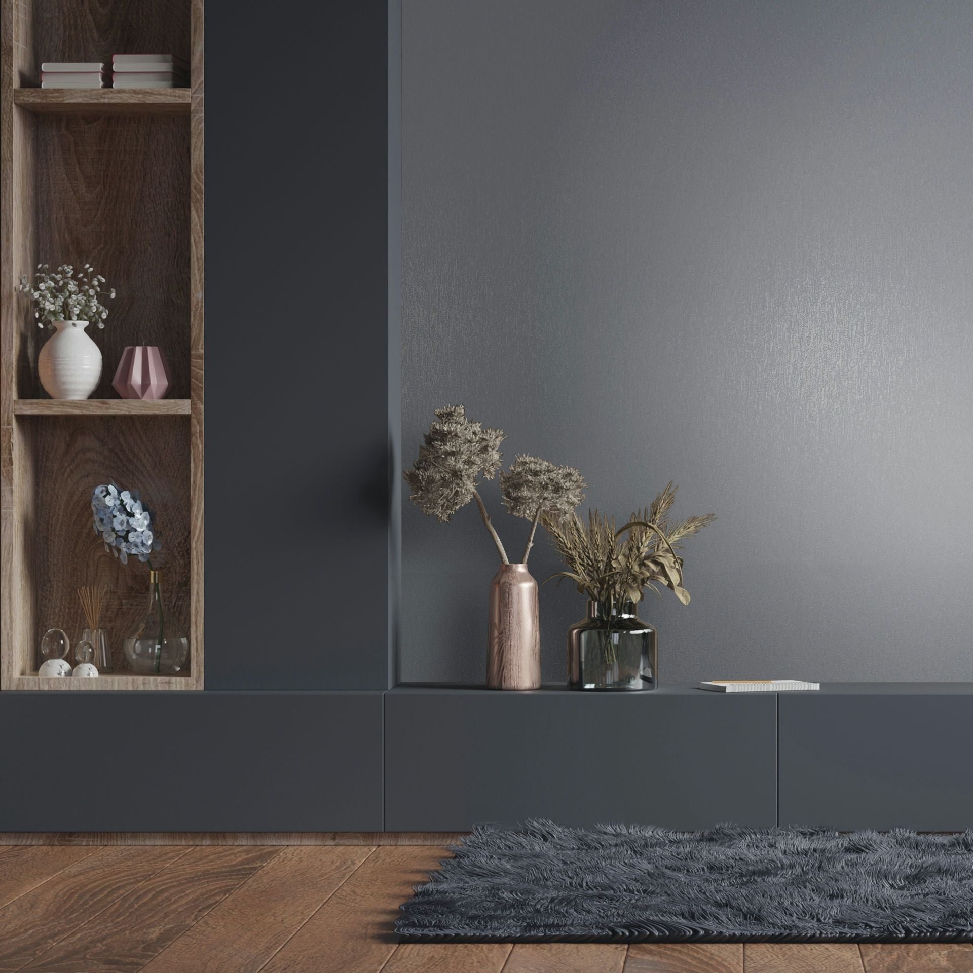 Marburg Naomi 82537 Gray wallpaper with a fine vertical texture behind a dark built-in console and wooden shelf. Two vases with dried plants sit on the console, with books and small decor on the shelf and a shag rug on a wood floor in front.