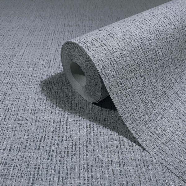 Marburg Naomi 82543 A gray wallpaper roll with a subtle crosshatch texture, partially unrolled on a matching surface.