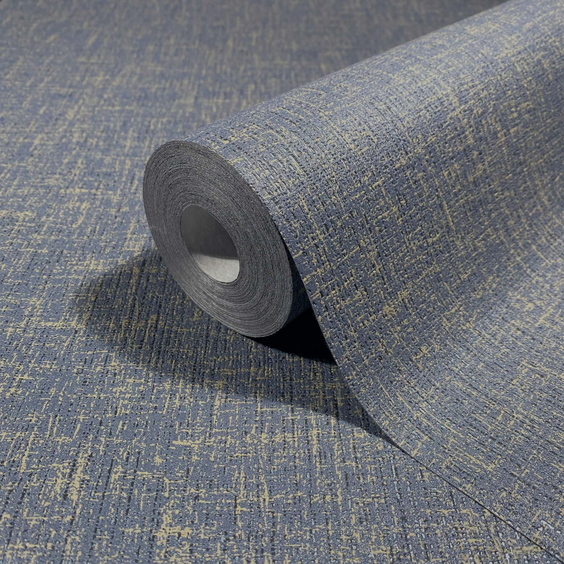 Marburg Naomi 82544 Close-up of a wallpaper roll showing an irregular crosshatch texture in blue-gray with light beige flecks, partially unrolled on the same design.