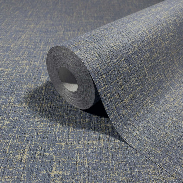 Marburg Naomi 82544 Close-up of a wallpaper roll showing an irregular crosshatch texture in blue-gray with light beige flecks, partially unrolled on the same design.