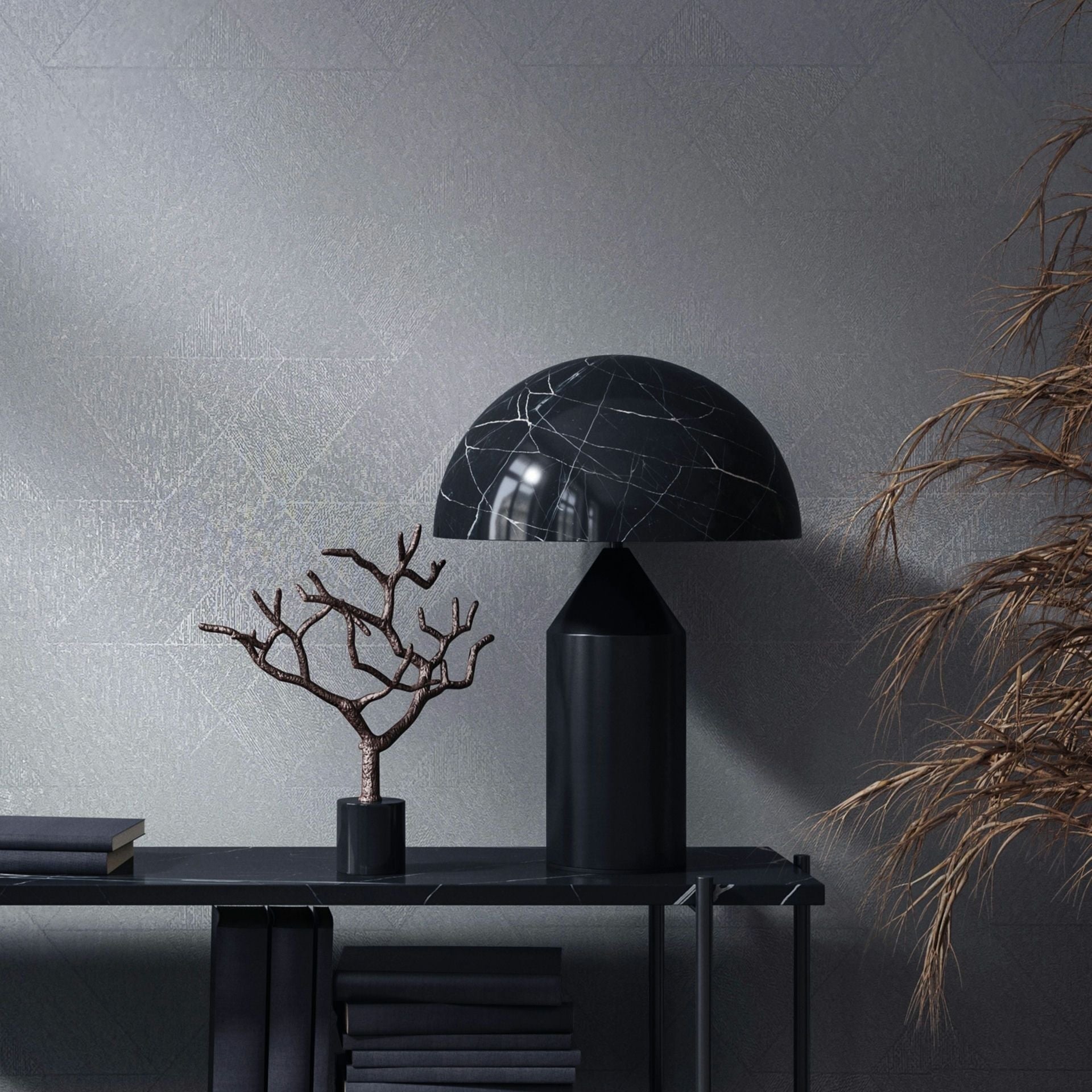 Marburg Naomi 82547 Tonal geometric wallpaper with a subtle line pattern shown behind a black dome table lamp on a slim console with stacked books and a small sculptural branch; dried foliage appears at the right edge.