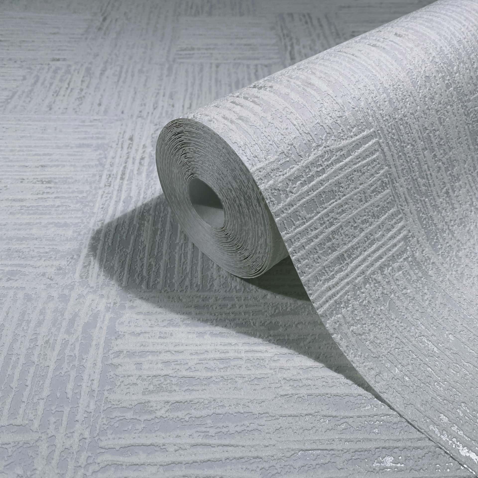 Marburg Naomi 82551 Close-up product shot of a wallpaper roll with a raised crosshatch texture in light grey, resting on an unrolled sheet of the same pattern.
