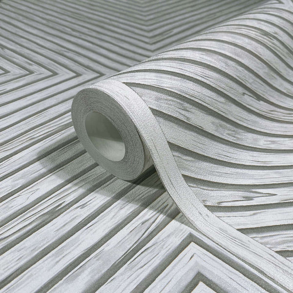 Marburg Naomi 89021 Close-up product view of a wallpaper roll partially unrolled across a gray and white chevron pattern with textured, layered stripes.