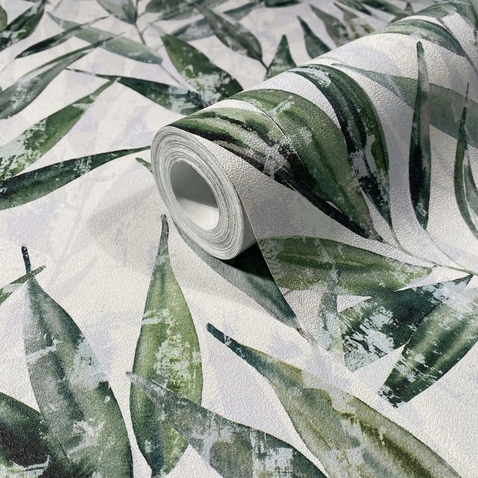 Marburg Naomi 89039 Wallpaper roll resting on matching surface with a painterly green leaf pattern on a light textured background.