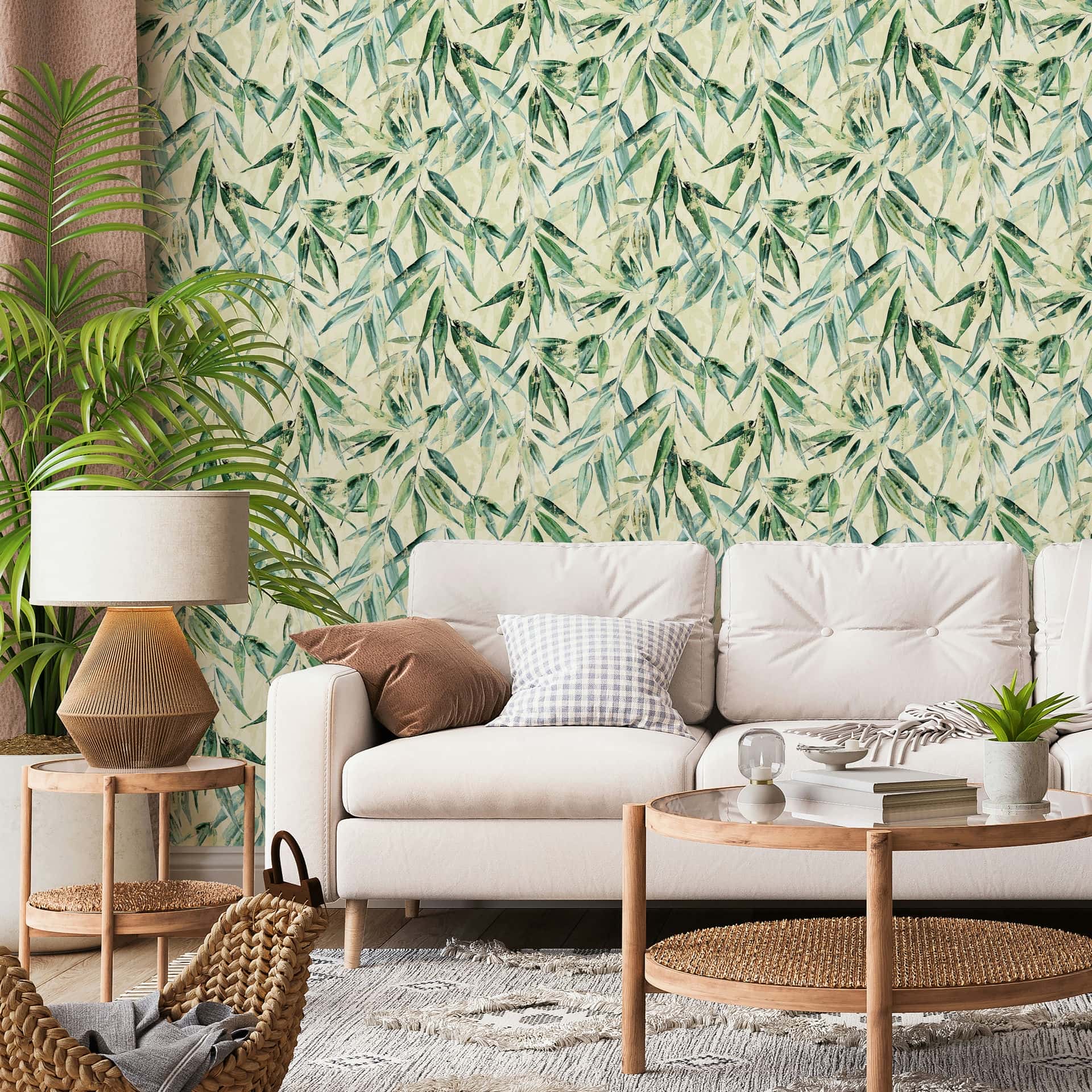 Marburg Naomi 89040 Green leafy botanical wallpaper with a light beige background behind a light sofa, round wooden coffee table, side table with a lamp, tall floor plant, small potted plant, woven basket, and rug.