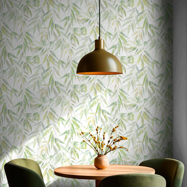 Marburg Naomi 89041 Green leaf pattern wallpaper on a white ground behind a round table with a vase and stems, two chairs, and a dome pendant light above.