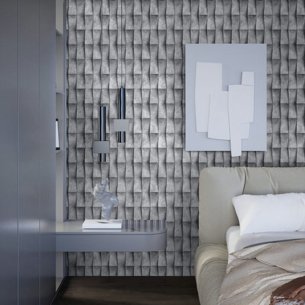 Marburg Novamur Mona 81649 Bedroom scene featuring gray 3D-effect geometric wallpaper behind a bed, with two chrome pendant lights, a floating shelf holding a small sculpture and book, and abstract wall art.