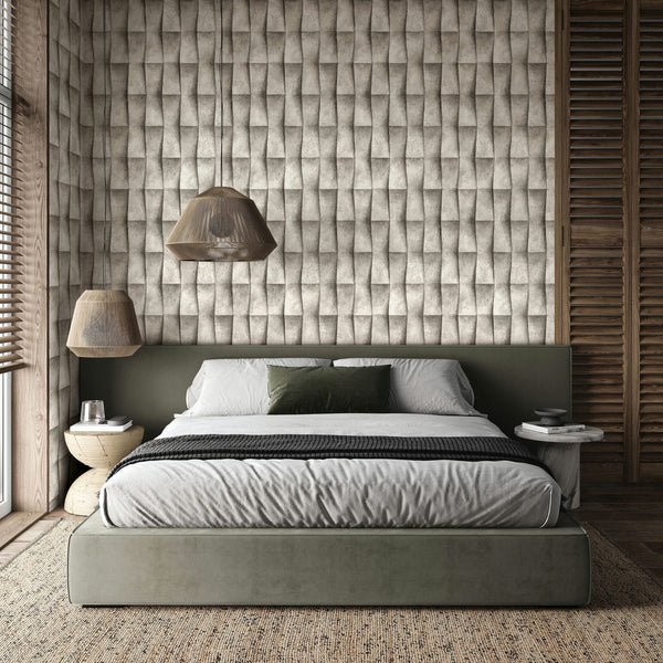 Marburg Novamur Mona 81650 Bedroom scene with a bed and twin pendant lights; the feature wall is covered in beige and grey geometric wallpaper that creates a folded 3D effect. Side tables, window blinds, and a textured rug are visible.