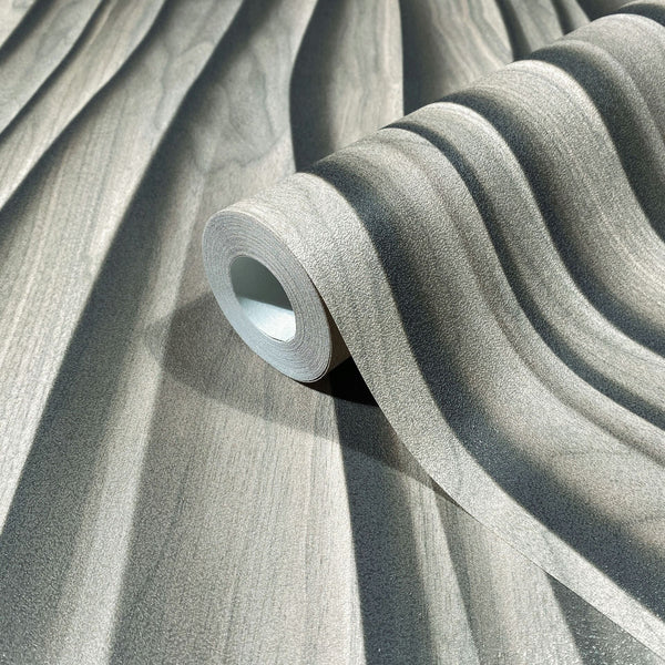 Marburg Novamur Mona 81665 Close-up of a wallpaper roll resting on matching paper, displaying a soft wavy stripe pattern in light beige-gray with a textured surface.