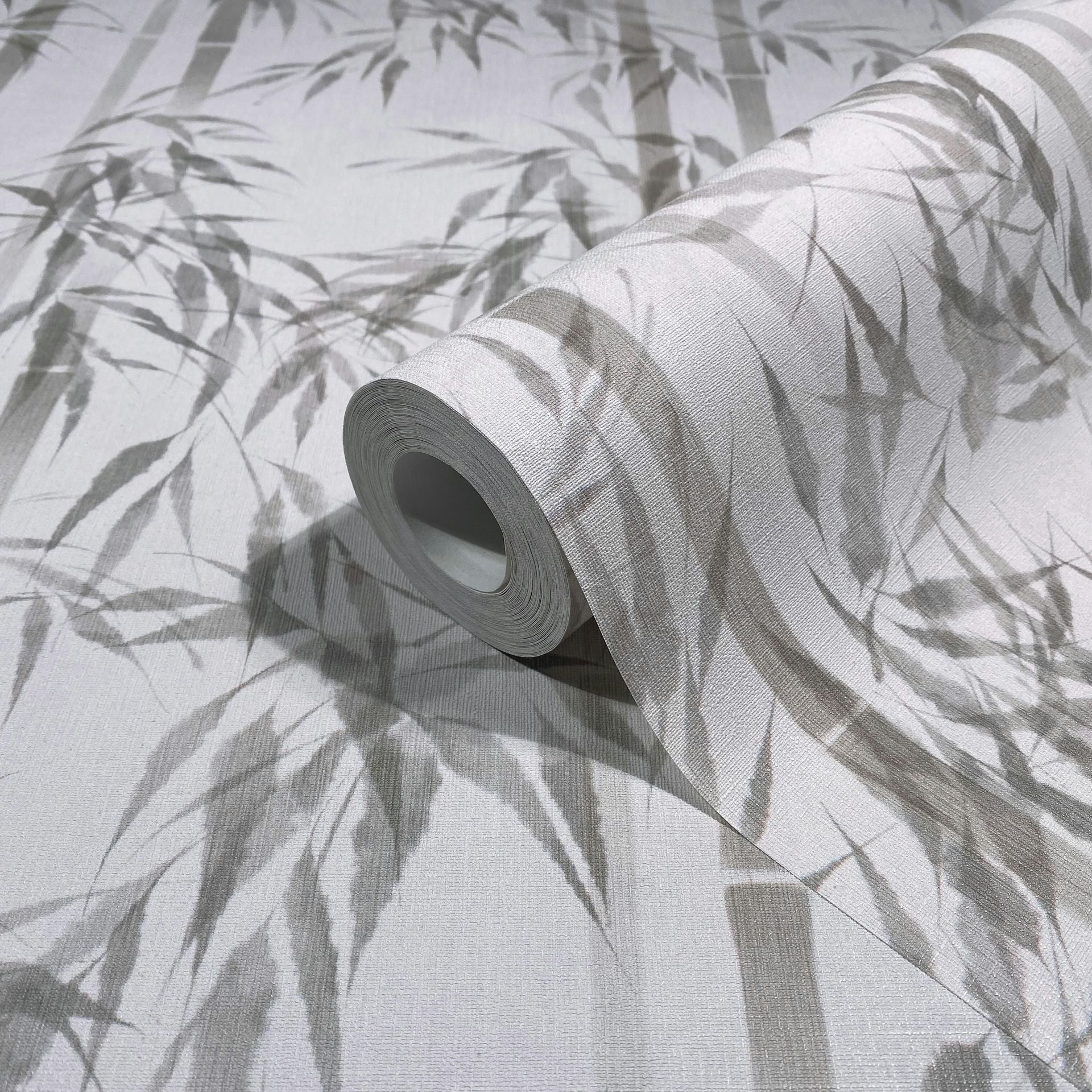 Marburg Novamur Mona 81671 Rolled wallpaper on a matching sheet featuring gray bamboo leaves and stems on a light background.