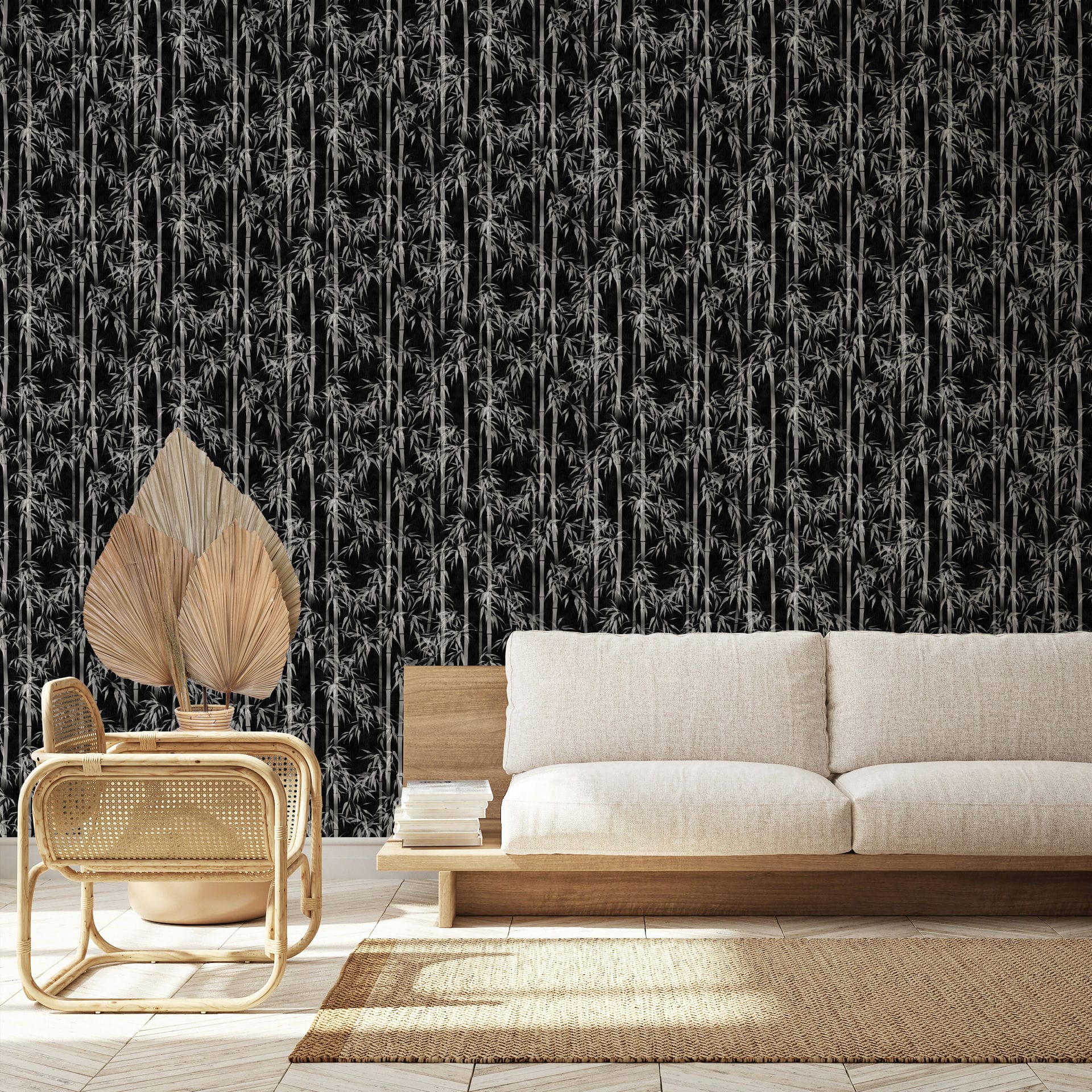 Marburg Novamur Mona 81672 Black wallpaper with a dense bamboo stalk and leaf pattern behind a light wood sofa and a rattan chair with dried leaves, with a natural fiber rug on the floor.