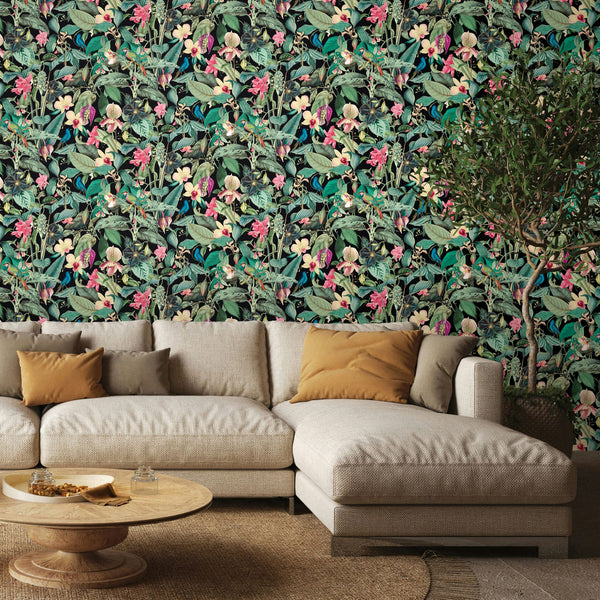 Marburg Novamur Mona 81685 Dense tropical botanical print with layered green leaves, pink and yellow flowers, and small birds,, wallpaper on a living room feature wall.