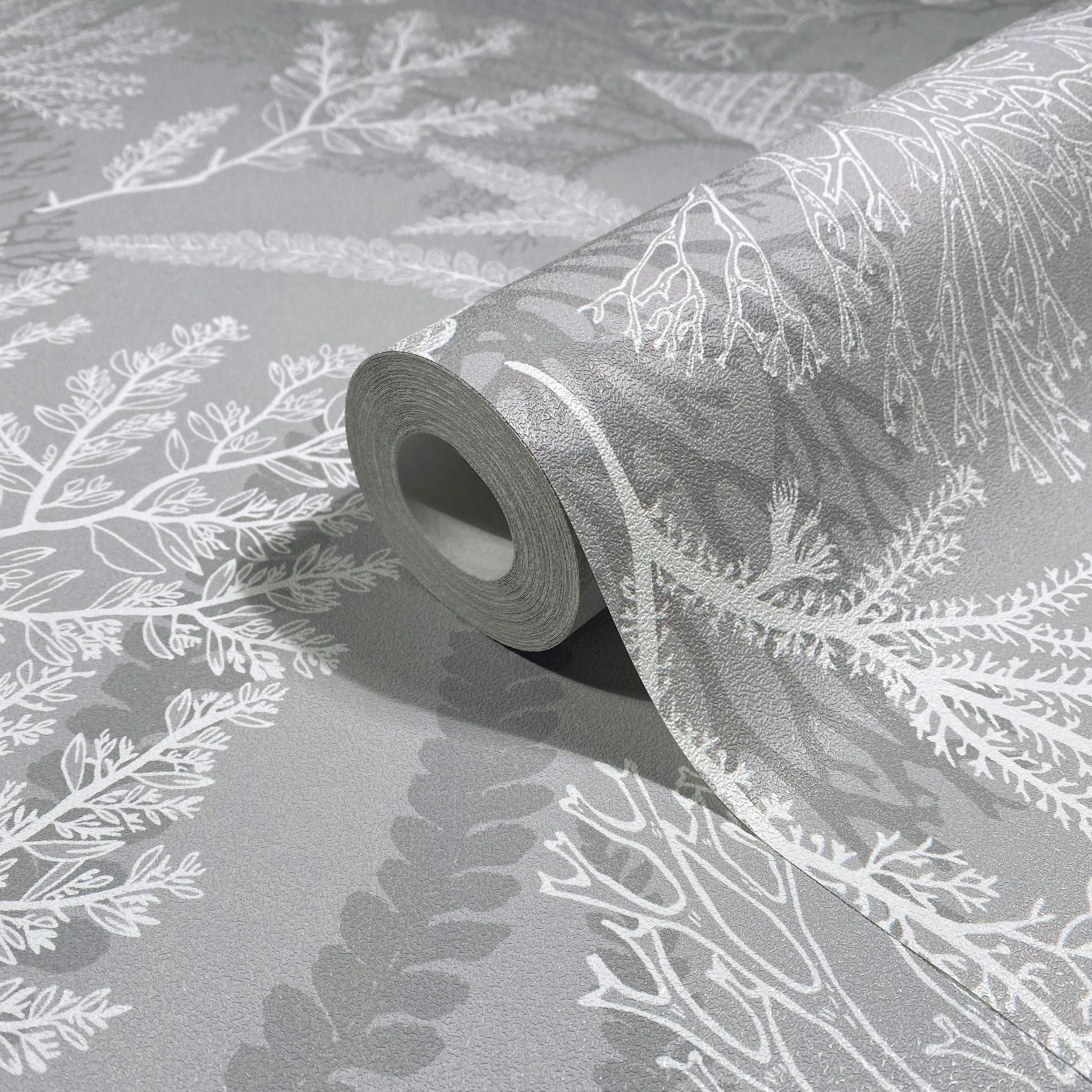 Marburg Novamur Mona 81687 Close-up of a gray textured wallpaper roll with white botanical leaf and branch pattern on a matching wallpaper surface.