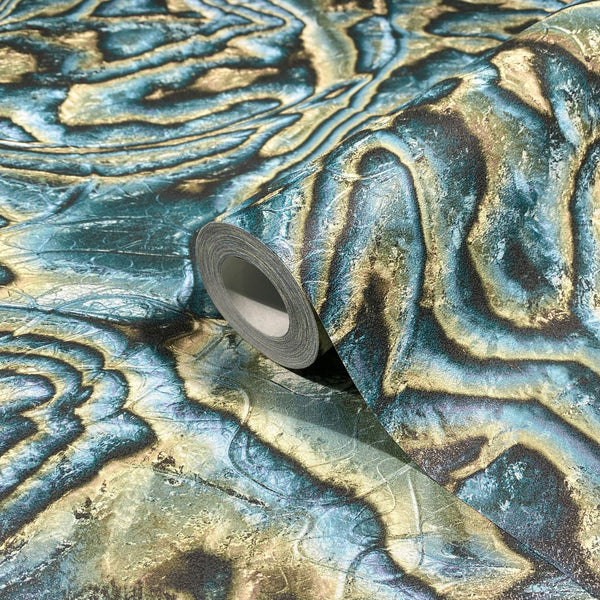 Marburg Novamur Mona 81692 A wallpaper roll resting on an unrolled sheet showing organic wavy bands in blue, green, and beige with a stone-like texture.