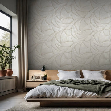 Marburg Ritus 35502 Bedroom scene featuring a light beige wallpaper with overlapping curved, petal-like swirls behind a low wooden bed with white bedding; a nightstand, lamp, and a window with plants sit to the left.