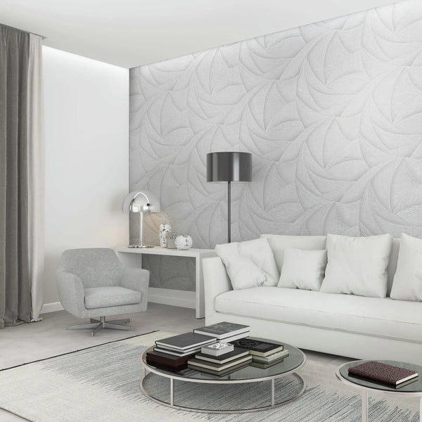 Marburg Ritus 35503 Living room scene with a light grey-white wallpaper featuring large overlapping swirl motifs used as a feature wall behind a white sofa. Round coffee tables with books, an armchair, a floor lamp, a console with a dome table lamp, curtains, and a rug are also,.