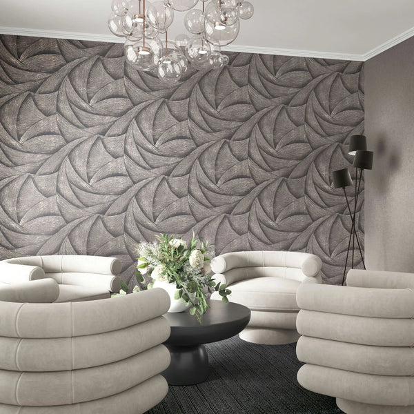 Marburg Ritus 35505 Living room scene featuring a dark abstract swirl-pattern wallpaper as a feature wall behind cream upholstered armchairs, a round black coffee table with a floral arrangement, a multi-head black floor lamp, and a glass globe chandelier.