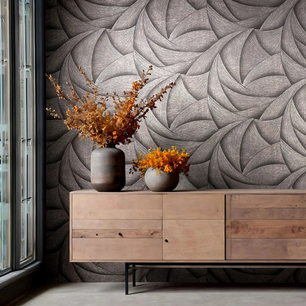 Marburg Ritus 35505 Abstract swirling pattern wallpaper in dark tonal shades behind a wooden sideboard with two vases of dried foliage, next to a tall window.