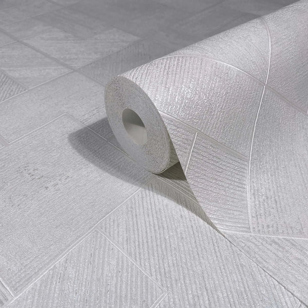 Marburg Ritus 35508 Close-up of a white textured wallpaper roll resting on matching surface with geometric rectangular panels and diagonal striations.