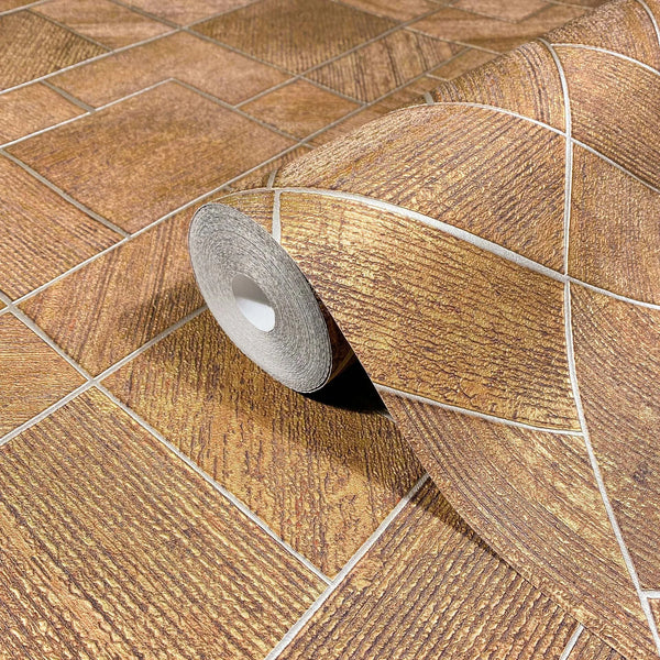 Marburg Ritus 35513 Wallpaper roll on matching surface showing a gold rectangular grid pattern with textured blocks and pale divider lines.